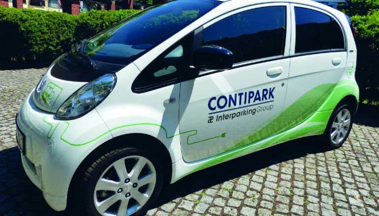 E-Mobilität: Ein Elektroauto mit einem Contipark-Schriftzug steht auf einem Parkplatz.